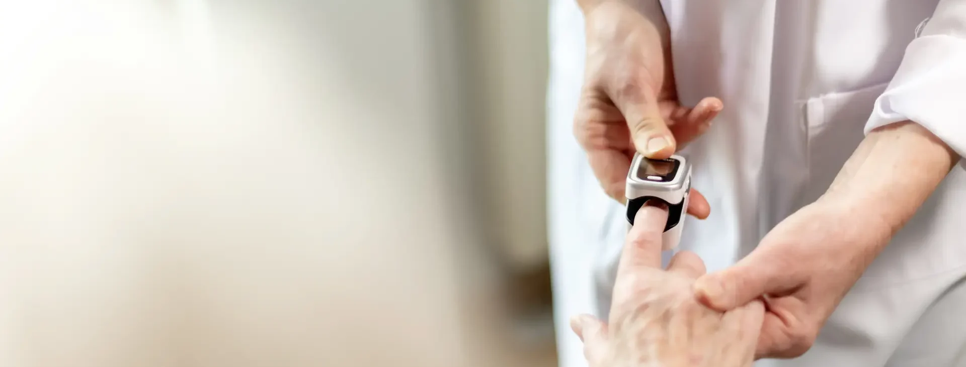 Arzt macht Pulsoxymeter an Finger von Patient