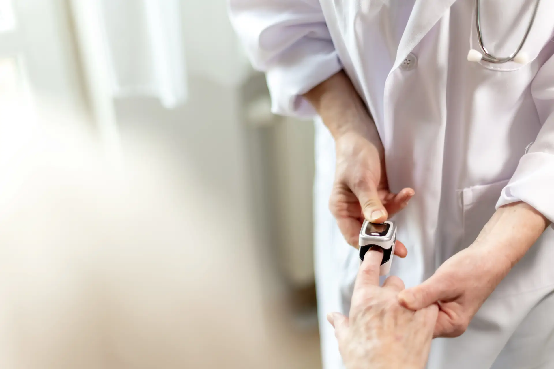 Arzt macht Pulsoxymeter an Finger von Patient